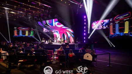 Corporate conference stage produced with LED walls, moving lights and live leaderboard screens above a seated audience