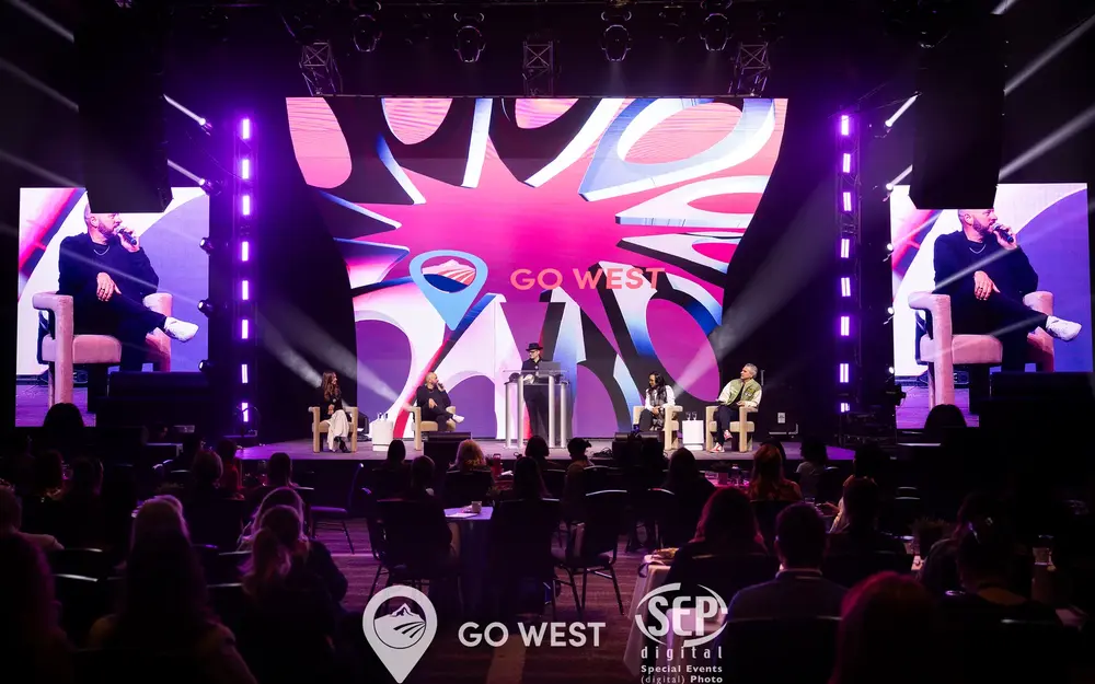 Conference main stage with LED walls and moving lights over a seated audience