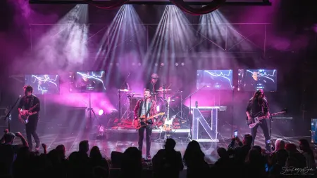Live band performing under purple stage lights for a packed crowd at a Fusion Events show