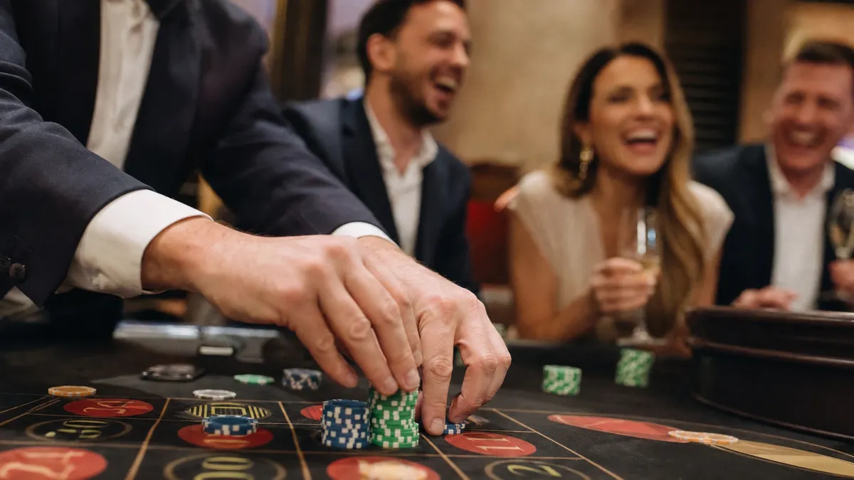 Hands stacking poker chips at a casino night roulette table