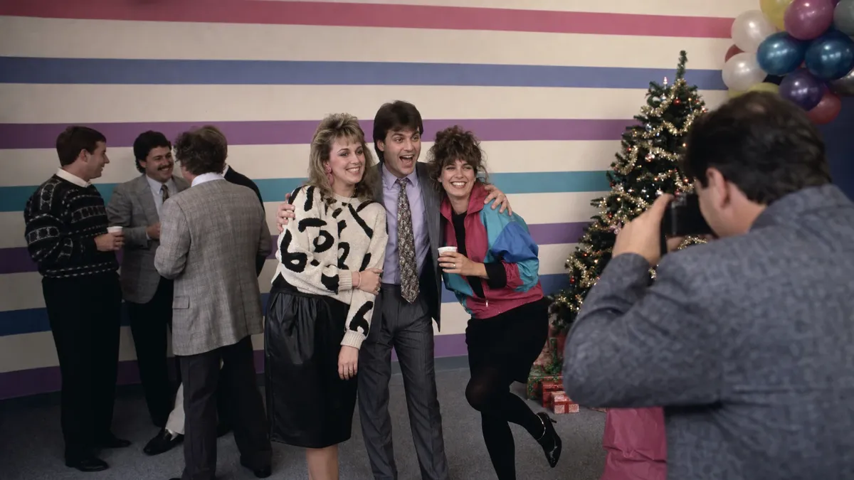 Retro decades themed office holiday party with employees in vintage attire
