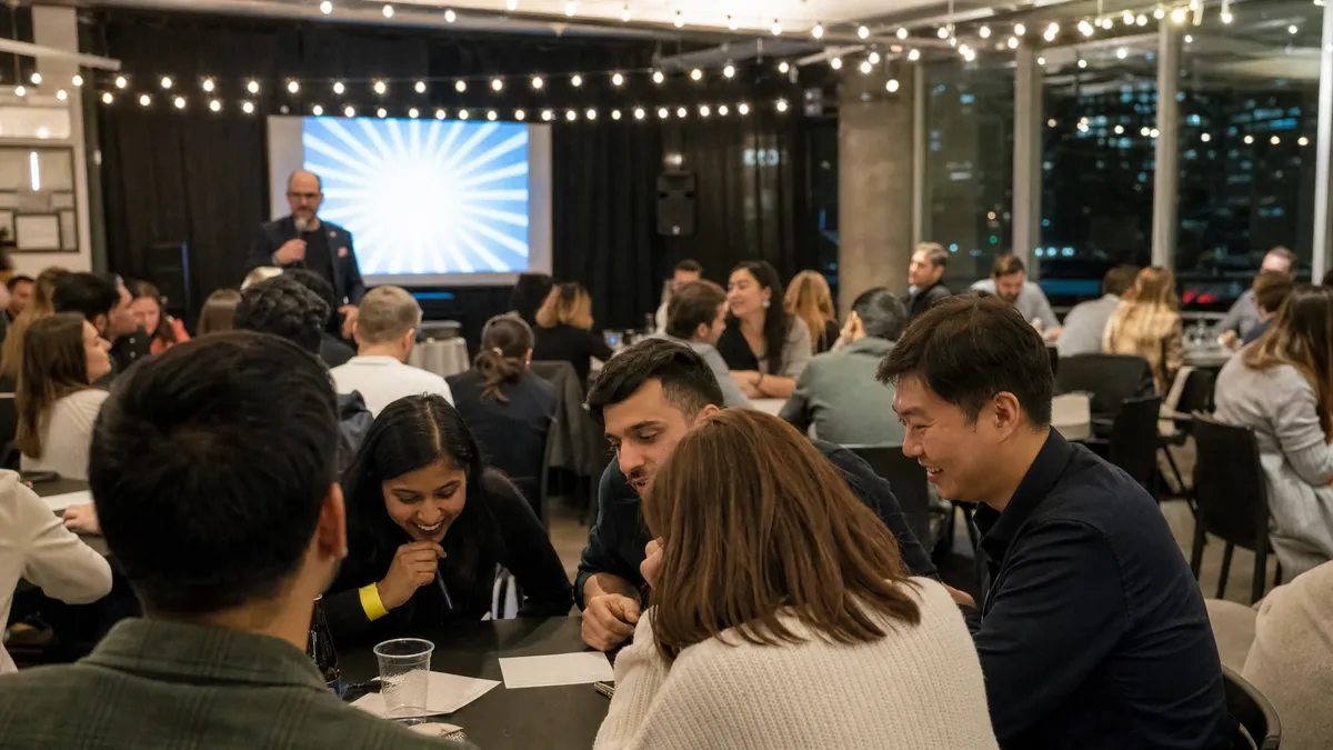 Corporate trivia night with teams huddled over answer sheets