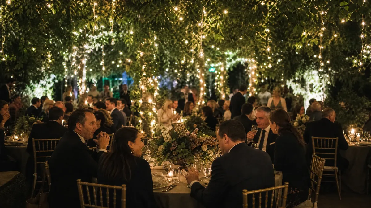 Enchanted garden themed gala under a canopy of greenery and lights