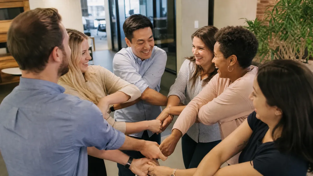 Colleagues laughing mid-tangle during a human knot icebreaker game
