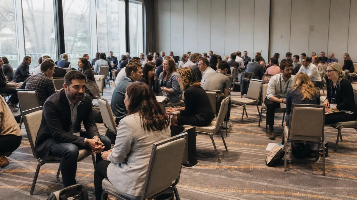 Large conference breakout with pairs of professionals talking during an icebreaker