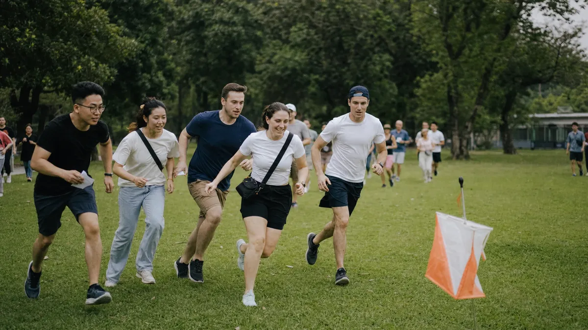 Teams racing to a checkpoint flag during an outdoor park challenge
