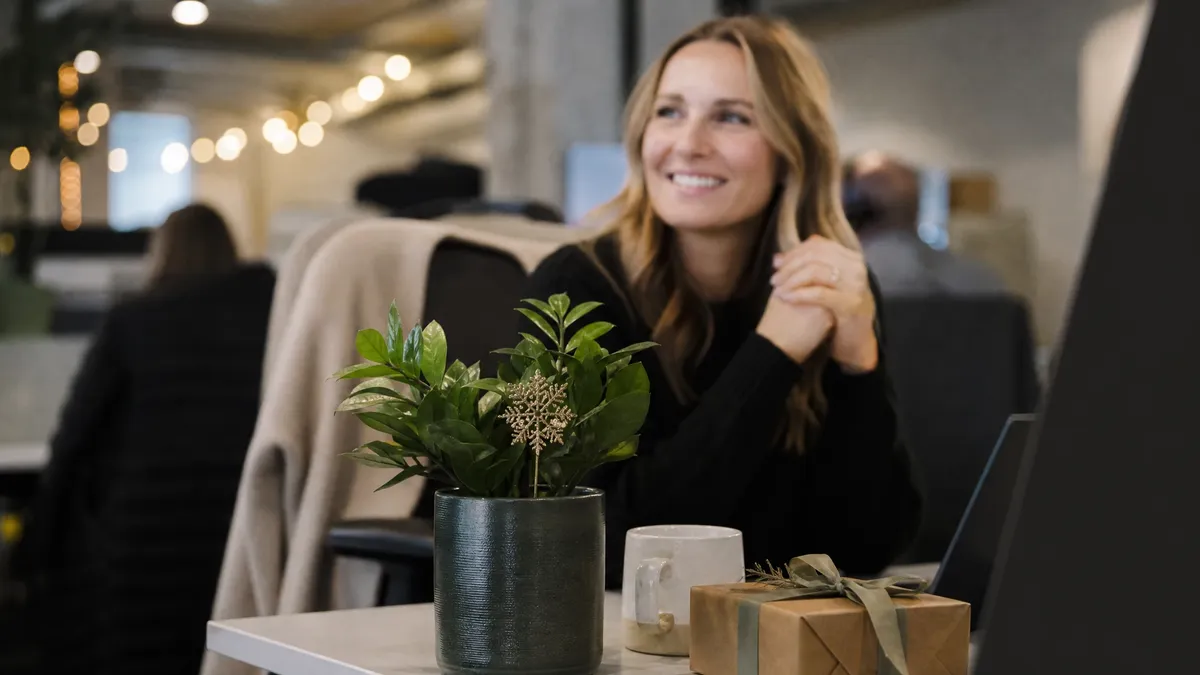 Desk decorated with a cozy mug, plant, and small secret santa gift box