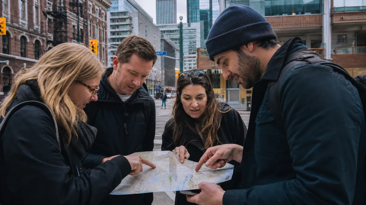 Small team consulting a map on a Toronto street during a micro adventure