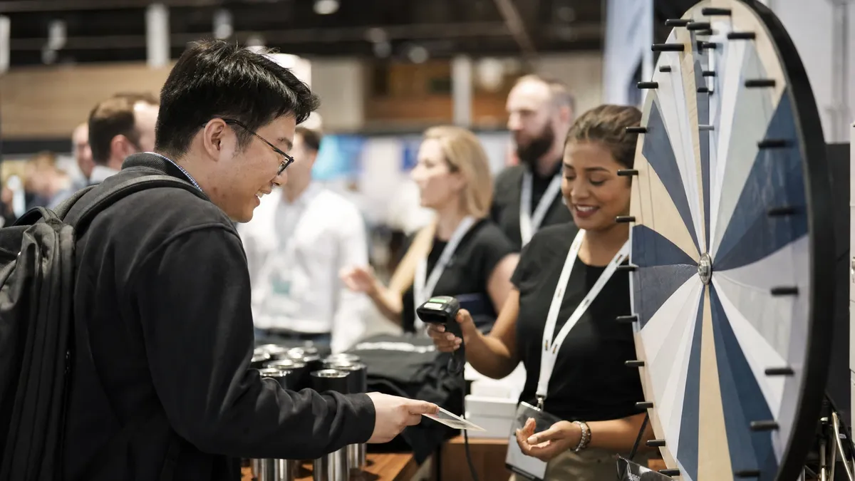 Trade show visitor playing a prize wheel while staff scan their badge