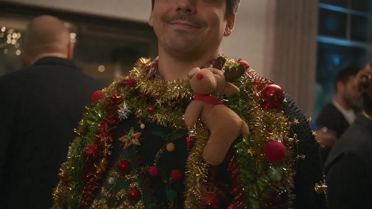 Close-up of an absurd DIY ugly christmas sweater with tinsel and ornaments