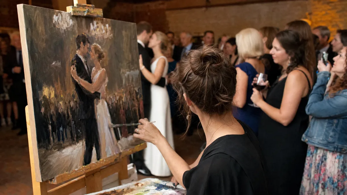 Live painter capturing the first dance on canvas at a wedding reception