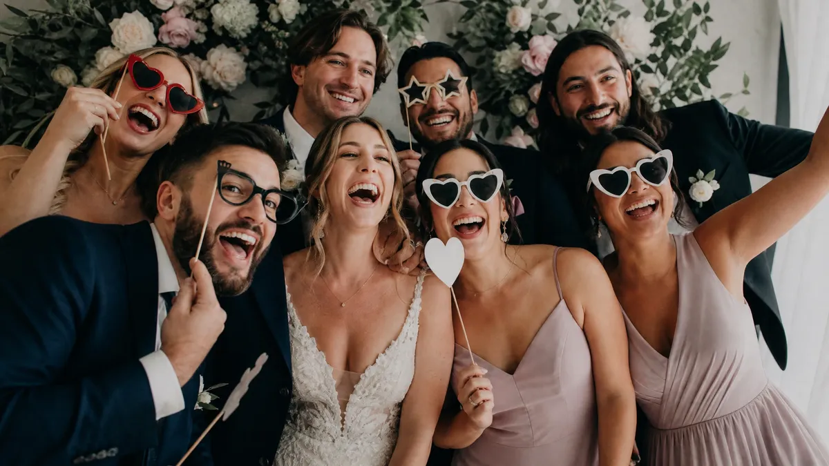 Bridal party posing with props in a wedding photo booth